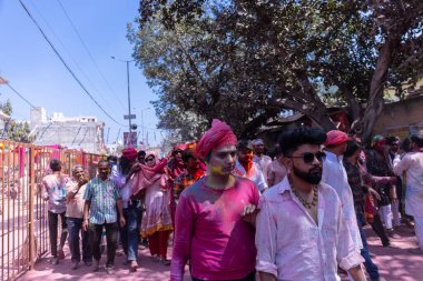 Barsana, Uttar Pradesh, Hindistan - 18 Mart 2024: Barsana sokaklarındaki Holi festivalini kuru organik renklerle kutlayan Hindu dindar grup.
