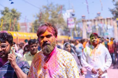 Barsana, Uttar Pradesh, Hindistan - 18 Mart 2024: Barsana sokaklarındaki Holi festivalini kuru organik renklerle kutlayan Hindu dindar grup.