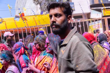 Barsana, Uttar Pradesh, Hindistan - 18 Mart 2024: Barsana sokaklarındaki Holi festivalini kuru organik renklerle kutlayan Hindu dindar grup.