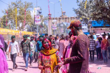 Barsana, Uttar Pradesh, Hindistan - 18 Mart 2024: Barsana sokaklarındaki Holi festivalini kuru organik renklerle kutlayan Hindu dindar grup.