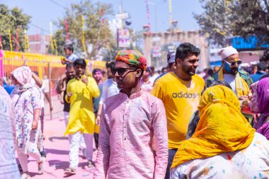 Barsana, Uttar Pradesh, Hindistan - 18 Mart 2024: Barsana sokaklarındaki Holi festivalini kuru organik renklerle kutlayan Hindu dindar grup.