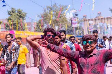 Barsana, Uttar Pradesh, Hindistan - 18 Mart 2024: Barsana sokaklarındaki Holi festivalini kuru organik renklerle kutlayan Hindu dindar grup.