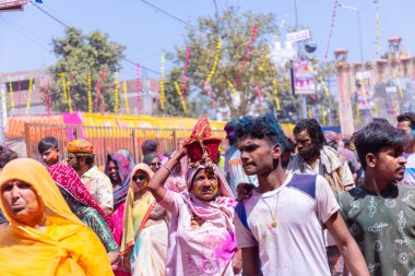 Barsana, Uttar Pradesh, Hindistan - 18 Mart 2024: Barsana sokaklarındaki Holi festivalini kuru organik renklerle kutlayan Hindu dindar grup.