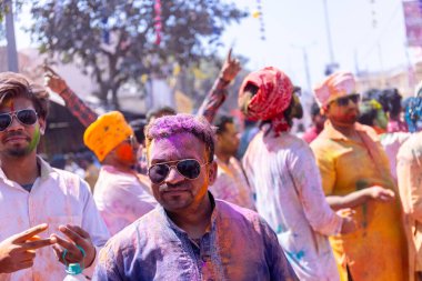 Barsana, Uttar Pradesh, Hindistan - 18 Mart 2024: Barsana sokaklarındaki Holi festivalini kuru organik renklerle kutlayan Hindu dindar grup.