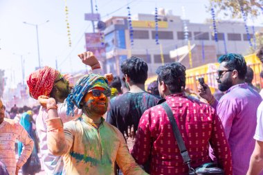 Barsana, Uttar Pradesh, Hindistan - 18 Mart 2024: Barsana sokaklarındaki Holi festivalini kuru organik renklerle kutlayan Hindu dindar grup.