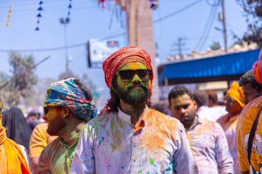 Barsana, Uttar Pradesh, Hindistan - 18 Mart 2024: Barsana sokaklarındaki Holi festivalini kuru organik renklerle kutlayan Hindu dindar grup.