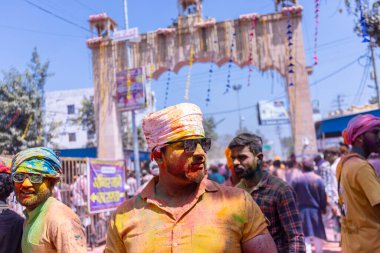 Barsana, Uttar Pradesh, Hindistan - 18 Mart 2024: Barsana sokaklarındaki Holi festivalini kuru organik renklerle kutlayan Hindu dindar grup.