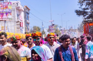 Barsana, Uttar Pradesh, Hindistan - 18 Mart 2024: Barsana sokaklarındaki Holi festivalini kuru organik renklerle kutlayan Hindu dindar grup.