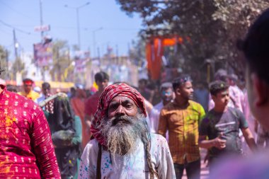Barsana, Uttar Pradesh, Hindistan - 18 Mart 2024: Barsana sokaklarındaki Holi festivalini kuru organik renklerle kutlayan Hindu dindar grup.