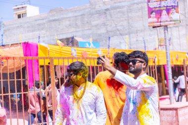 Barsana, Uttar Pradesh, Hindistan - 18 Mart 2024: Barsana sokaklarındaki Holi festivalini kuru organik renklerle kutlayan Hindu dindar grup.