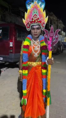 Thiruchendur, Tamilnadu, Hindistan - Ekim 2024: 4k clip, Hintli dindar portresi boyalı yüz ve Hindu tanrısı gibi giyinmiş geceleri kulasai dasara tarikat festivalini gerçekleştirmek için.