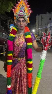 Thiruchendur, Tamilnadu, Hindistan - Ekim 2024: 4k clip, Hintli dindar portresi boyalı yüz ve Hindu tanrısı gibi giyinmiş geceleri kulasai dasara tarikat festivalini gerçekleştirmek için.