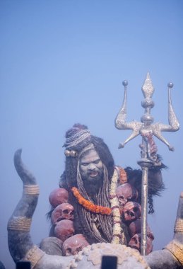 Varanasi, Uttar Pradesh, Hindistan - Mart 03: 2023: Masan Holi, Harishchandra ghat 'ta düzenlenen İstanbul bayramı sırasında efendi shiva gibi giyinmiş kuru külle boyanmış bir erkek dindar portresi.