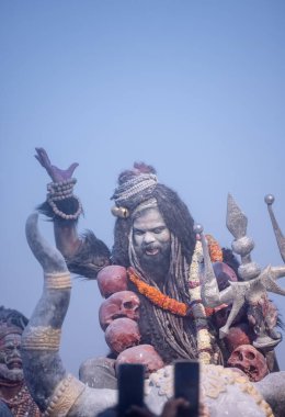 Varanasi, Uttar Pradesh, Hindistan - Mart 03: 2023: Masan Holi, Harishchandra ghat 'ta düzenlenen İstanbul bayramı sırasında efendi shiva gibi giyinmiş kuru külle boyanmış bir erkek dindar portresi.