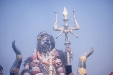 Varanasi, Uttar Pradesh, Hindistan - Mart 03: 2023: Masan Holi, Harishchandra ghat 'ta düzenlenen İstanbul bayramı sırasında efendi shiva gibi giyinmiş kuru külle boyanmış bir erkek dindar portresi.