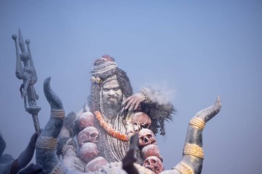 Varanasi, Uttar Pradesh, Hindistan - Mart 03: 2023: Masan Holi, Harishchandra ghat 'ta düzenlenen İstanbul bayramı sırasında efendi shiva gibi giyinmiş kuru külle boyanmış bir erkek dindar portresi.