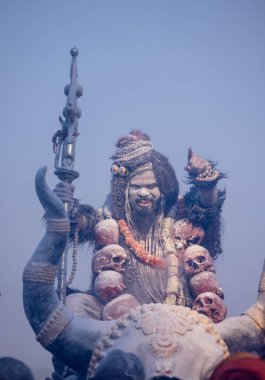 Varanasi, Uttar Pradesh, Hindistan - Mart 03: 2023: Masan Holi, Harishchandra ghat 'ta düzenlenen İstanbul bayramı sırasında efendi shiva gibi giyinmiş kuru külle boyanmış bir erkek dindar portresi.