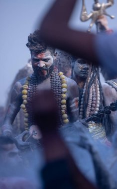 Varanasi, Uttar Pradesh, Hindistan - Mart 03: 2023: Masan Holi, Harishchandra ghat 'ta düzenlenen İstanbul bayramı sırasında efendi shiva gibi giyinmiş kuru külle boyanmış bir erkek dindar portresi.