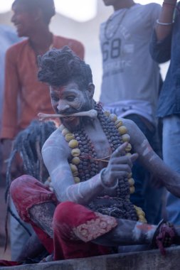 Varanasi, Uttar Pradesh, Hindistan - Mart 03: 2023: Masan Holi, Harishchandra ghat 'ta düzenlenen İstanbul bayramı sırasında efendi shiva gibi giyinmiş kuru külle boyanmış bir erkek dindar portresi.