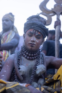 Varanasi, Uttar Pradesh, Hindistan - Mart 03: 2023: Masan Holi, Harishchandra ghat 'ta düzenlenen İstanbul bayramı sırasında efendi shiva gibi giyinmiş kuru külle boyanmış bir erkek dindar portresi.