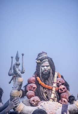 Varanasi, Uttar Pradesh, Hindistan - Mart 03: 2023: Masan Holi, Harishchandra ghat 'ta düzenlenen İstanbul bayramı sırasında efendi shiva gibi giyinmiş kuru külle boyanmış bir erkek dindar portresi.