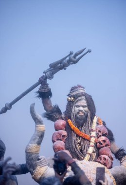 Varanasi, Uttar Pradesh, Hindistan - Mart 03: 2023: Masan Holi, Harishchandra ghat 'ta düzenlenen İstanbul bayramı sırasında efendi shiva gibi giyinmiş kuru külle boyanmış bir erkek dindar portresi.