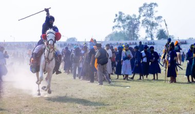 Anandpur Sahib, Punjab, India - March 19 2022: Group of sikh people (Nihang Sardar) during the celebration of Hola Mohalla festival at Anandpur Sahib streets during the holi festival. Selected focus. clipart