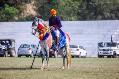 Anandpur Sahib, Punjab, India - March 19 2022: Group of sikh people (Nihang Sardar) during the celebration of Hola Mohalla festival at Anandpur Sahib streets during the holi festival. Selected focus. clipart