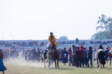Anandpur Sahib, Punjab, Hindistan - 19 Mart 2022: Hola Mohalla festivali sırasında Hola Mohalla kutlamaları sırasında bir grup sikh insan (Nihang Sardar) Holi festivali sırasında Anandpur Sahib sokaklarında. Seçili odak.