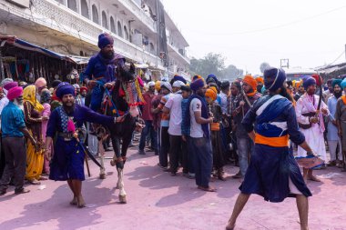 Anandpur Sahib, Punjab, Hindistan - 19 Mart 2022: Hola Mohalla festivali sırasında Hola Mohalla kutlamaları sırasında bir grup sikh insan (Nihang Sardar) Holi festivali sırasında Anandpur Sahib sokaklarında. Seçili odak.