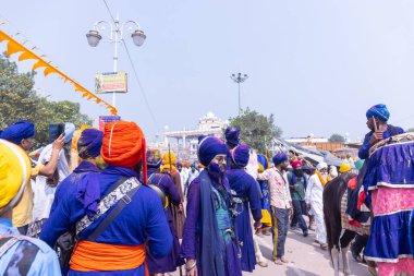 Anandpur Sahib, Punjab, Hindistan - 19 Mart 2022: Hola Mohalla festivali sırasında Hola Mohalla kutlamaları sırasında bir grup sikh insan (Nihang Sardar) Holi festivali sırasında Anandpur Sahib sokaklarında. Seçili odak.