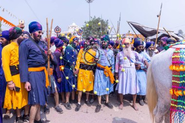 Anandpur Sahib, Punjab, Hindistan - 19 Mart 2022: Hola Mohalla festivali sırasında Hola Mohalla kutlamaları sırasında bir grup sikh insan (Nihang Sardar) Holi festivali sırasında Anandpur Sahib sokaklarında. Seçili odak.