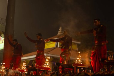 Varanasi, Uttar Pradesh, Hindistan - 20 Ocak 2024: Ganga aarti, genç bir Hindu papazın portresi sabahın erken saatlerinde Assi Ghat 'ta geleneksel ayinlerle geleneksel kıyafetlerle Ganga nehri aarti sergiliyor..