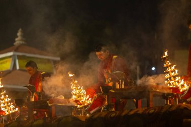 Varanasi, Uttar Pradesh, Hindistan - 20 Ocak 2024: Ganga aarti, genç bir Hindu papazın portresi sabahın erken saatlerinde Assi Ghat 'ta geleneksel ayinlerle geleneksel kıyafetlerle Ganga nehri aarti sergiliyor..