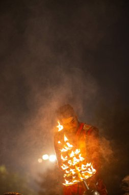 Varanasi, Uttar Pradesh, Hindistan - 20 Ocak 2024: Ganga aarti, genç bir Hindu papazın portresi sabahın erken saatlerinde Assi Ghat 'ta geleneksel ayinlerle geleneksel kıyafetlerle Ganga nehri aarti sergiliyor..
