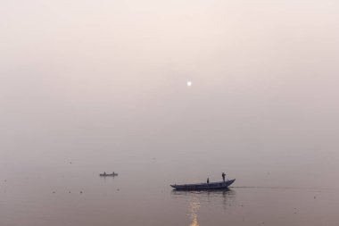 Varanasi 'de kış sabahı nehir keneviri kıyısında yüzen ya da parkeden tahta botlar..