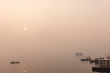 Varanasi 'de kış sabahı nehir keneviri kıyısında yüzen ya da parkeden tahta botlar..