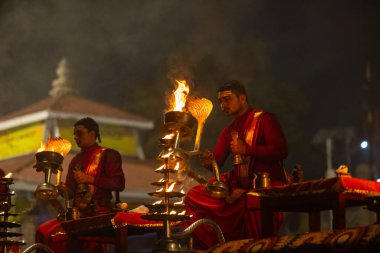 Varanasi, Uttar Pradesh, Hindistan - 20 Ocak 2024: Ganga aarti, genç bir Hindu papazın portresi sabahın erken saatlerinde Assi Ghat 'ta geleneksel ayinlerle geleneksel kıyafetlerle Ganga nehri aarti sergiliyor..