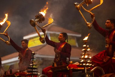 Varanasi, Uttar Pradesh, Hindistan - 20 Ocak 2024: Ganga aarti, genç bir Hindu papazın portresi sabahın erken saatlerinde Assi Ghat 'ta geleneksel ayinlerle geleneksel kıyafetlerle Ganga nehri aarti sergiliyor..