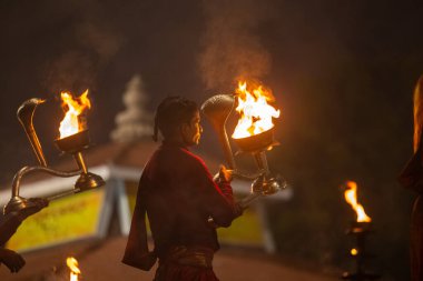 Varanasi, Uttar Pradesh, Hindistan - 20 Ocak 2024: Ganga aarti, genç bir Hindu papazın portresi sabahın erken saatlerinde Assi Ghat 'ta geleneksel ayinlerle geleneksel kıyafetlerle Ganga nehri aarti sergiliyor..