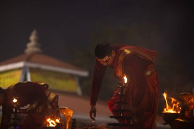 Varanasi, Uttar Pradesh, Hindistan - 20 Ocak 2024: Ganga aarti, genç bir Hindu papazın portresi sabahın erken saatlerinde Assi Ghat 'ta geleneksel ayinlerle geleneksel kıyafetlerle Ganga nehri aarti sergiliyor..