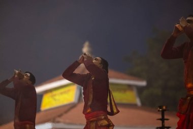 Varanasi, Uttar Pradesh, Hindistan - 20 Ocak 2024: Ganga aarti, genç bir Hindu papazın portresi sabahın erken saatlerinde Assi Ghat 'ta geleneksel ayinlerle geleneksel kıyafetlerle Ganga nehri aarti sergiliyor..