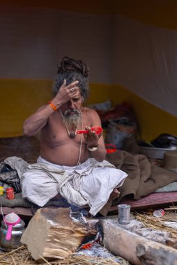 Prayagraj, Uttar Pradesh, Hindistan - 13 Ocak 2025: Mahakumbh, Sangam 'da Ganga nehrine kutsal dalış yapmak ve ibadet etmek için maha kumbh mela' ya katılan kutsal erkek çocuk portresi.