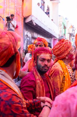 Barsana, Uttar Pradesh, Hindistan - 18 Mart 2024: Geleneksel giysiler ve rengarenk yüzlü Hindu erkek grubu, Barsana 'nın Rangili Gali' sindeki lathmar Holi 'yi geleneksel olarak kutluyorlar..