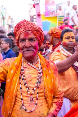 Barsana, Uttar Pradesh, Hindistan - 18 Mart 2024: Geleneksel giysiler ve rengarenk yüzlü Hindu erkek grubu, Barsana 'nın Rangili Gali' sindeki lathmar Holi 'yi geleneksel olarak kutluyorlar..
