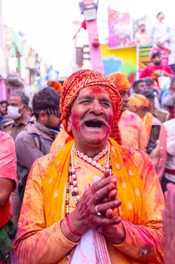 Barsana, Uttar Pradesh, Hindistan - 18 Mart 2024: Geleneksel giysiler ve rengarenk yüzlü Hindu erkek grubu, Barsana 'nın Rangili Gali' sindeki lathmar Holi 'yi geleneksel olarak kutluyorlar..