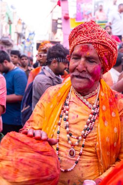 Barsana, Uttar Pradesh, Hindistan - 18 Mart 2024: Geleneksel giysiler ve rengarenk yüzlü Hindu erkek grubu, Barsana 'nın Rangili Gali' sindeki lathmar Holi 'yi geleneksel olarak kutluyorlar..