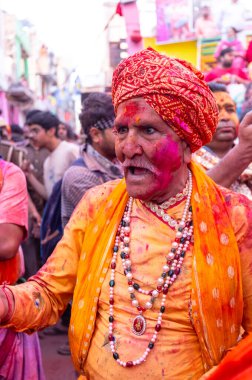 Barsana, Uttar Pradesh, Hindistan - 18 Mart 2024: Geleneksel giysiler ve rengarenk yüzlü Hindu erkek grubu, Barsana 'nın Rangili Gali' sindeki lathmar Holi 'yi geleneksel olarak kutluyorlar..