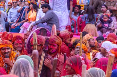 Barsana, Uttar Pradesh, Hindistan - 18 Mart 2024: Geleneksel giysiler ve rengarenk yüzlü Hindu erkek grubu, Barsana 'nın Rangili Gali' sindeki lathmar Holi 'yi geleneksel olarak kutluyorlar..
