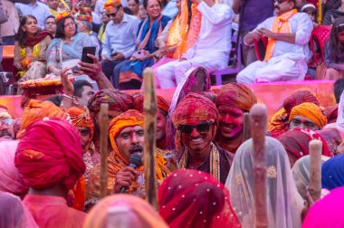 Barsana, Uttar Pradesh, Hindistan - 18 Mart 2024: Geleneksel giysiler ve rengarenk yüzlü Hindu erkek grubu, Barsana 'nın Rangili Gali' sindeki lathmar Holi 'yi geleneksel olarak kutluyorlar..